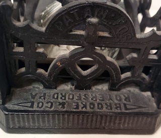 Brooke & Co. Cast Iron Mechanical Inkwell and Pen Holder with Japanese Geisha Motifs.